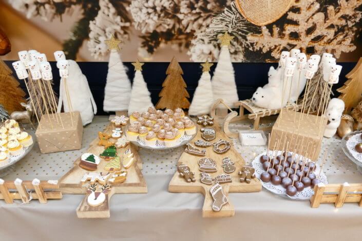 Noel nature par studio candy avec une décoration en beige et doré, des cakepops au chocolat, des mini cupcakes, des sablés décorés de Noël, un candy bar de chocolats et des ballons mignons pour les enfants