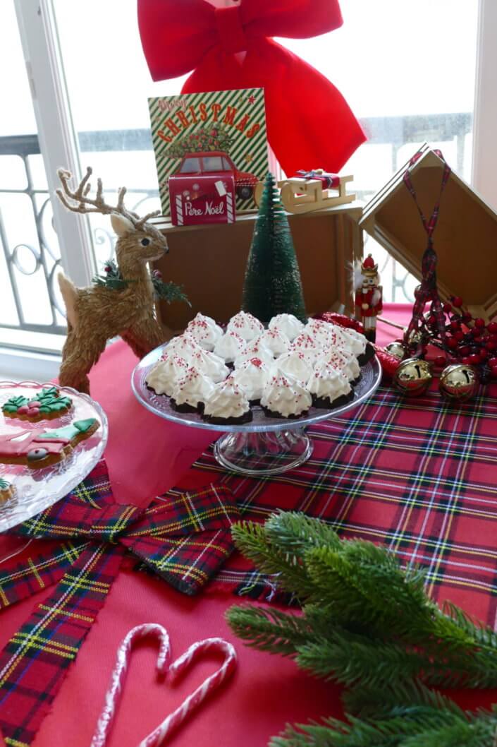 Noël des enfants chez Filorga par Studio Candy avec table décorée en rouge et vert sapin, sablés de Noël, chamallows, candy bar, mini cupcakes, meringues en forme de sapins, cakepops rouges pailletés