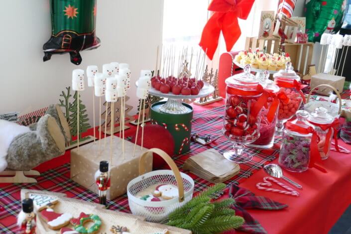 Noël des enfants chez Filorga par Studio Candy avec table décorée en rouge et vert sapin, sablés de Noël, chamallows, candy bar, mini cupcakes, meringues en forme de sapins, cakepops rouges pailletés