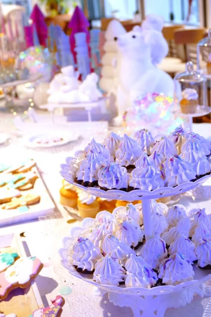 winter wonderland au gouter réalisé chez unibail par studio candy avec des sapins meringue, des cupcakes, des cakepops des sablés décorés de Noël, un candy bar et une décoration en blanc et pastels