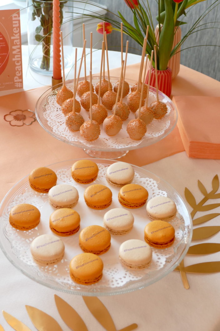 Evénement pêche Estée Lauder par Studio Candy avec table sur mesure décorée avec cakepops et cupcakes pêches, sablés décorés personnalisés, planches cocktail estivales et fontaines à boissons