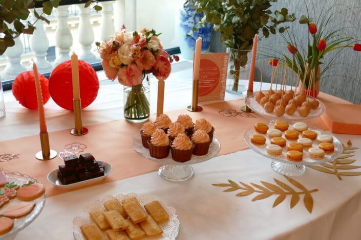 Evénement pêche Estée Lauder par Studio Candy avec table sur mesure décorée avec cakepops et cupcakes pêches, sablés décorés personnalisés, planches cocktail estivales et fontaines à boissons