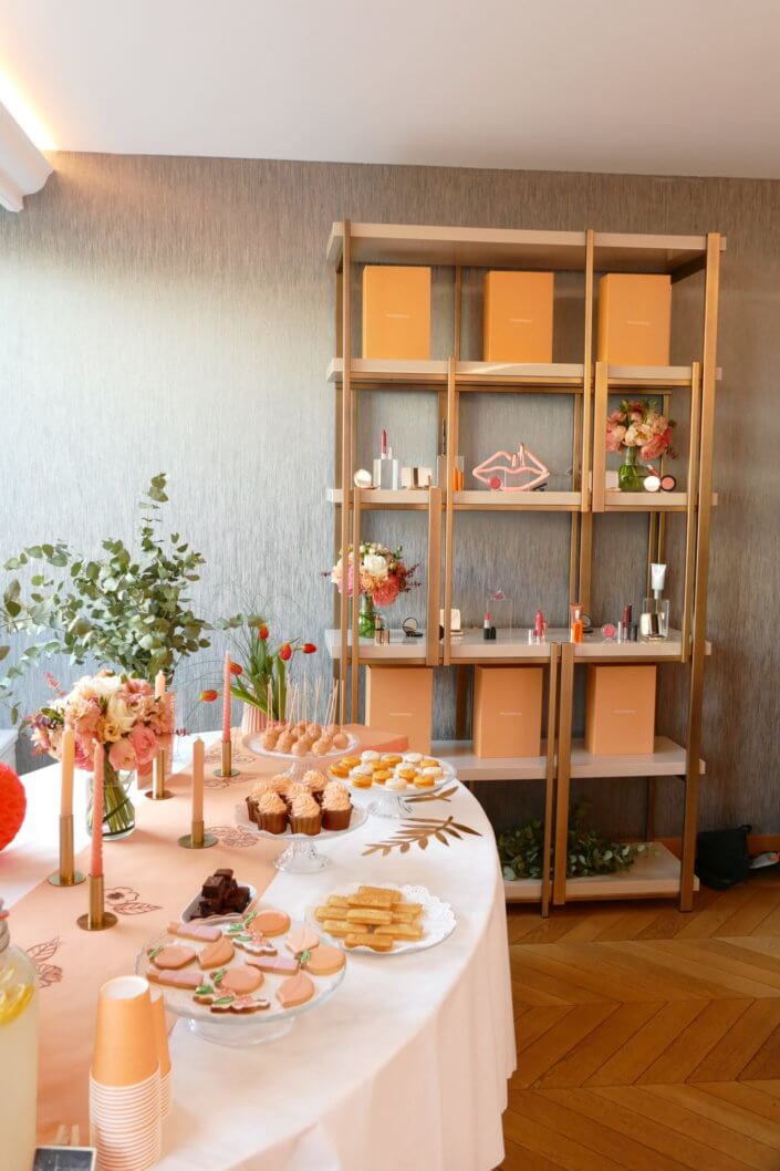 Evénement pêche Estée Lauder par Studio Candy avec table sur mesure décorée avec cakepops et cupcakes pêches, sablés décorés personnalisés, planches cocktail estivales et fontaines à boissons