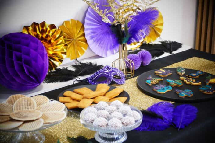 Afterwork Carnaval chez Bleu Libellule par Studio Candy avec décoration et set up sur mesure avec masques, plumes, vases, sablés décorés, brochettes de meringues, boissons
