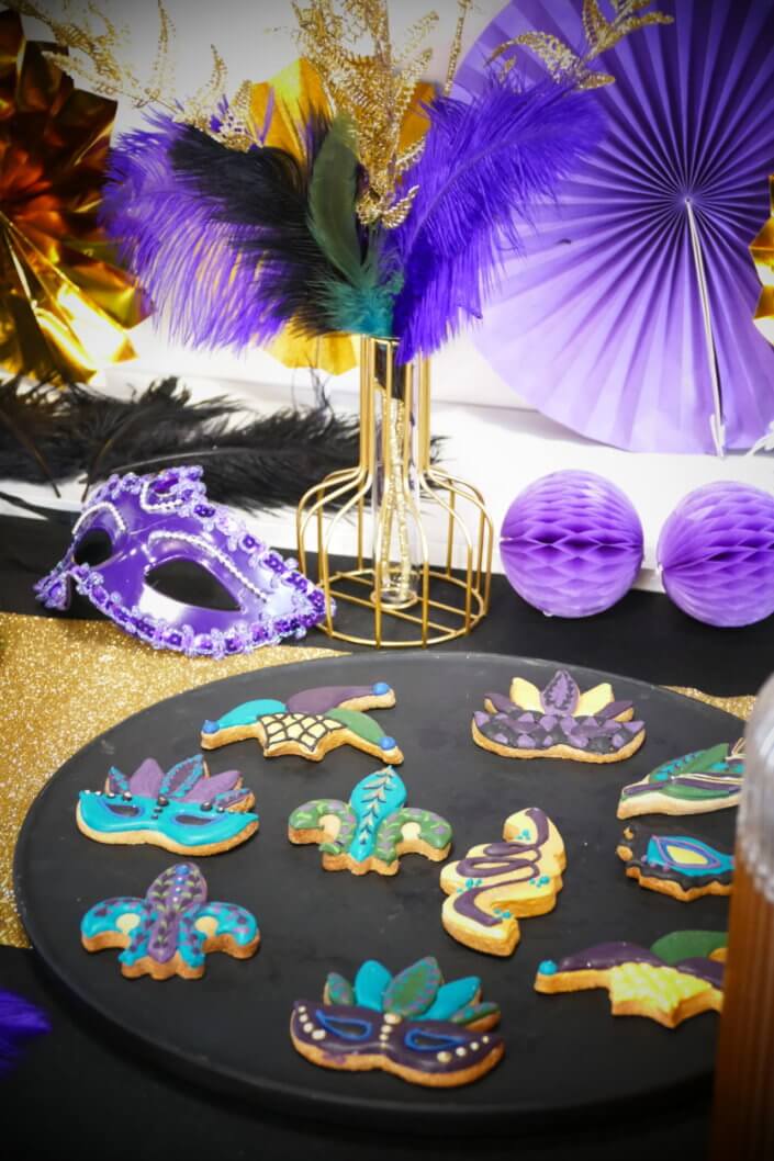 Afterwork Carnaval chez Bleu Libellule par Studio Candy avec décoration et set up sur mesure avec masques, plumes, vases, sablés décorés, brochettes de meringues, boissons