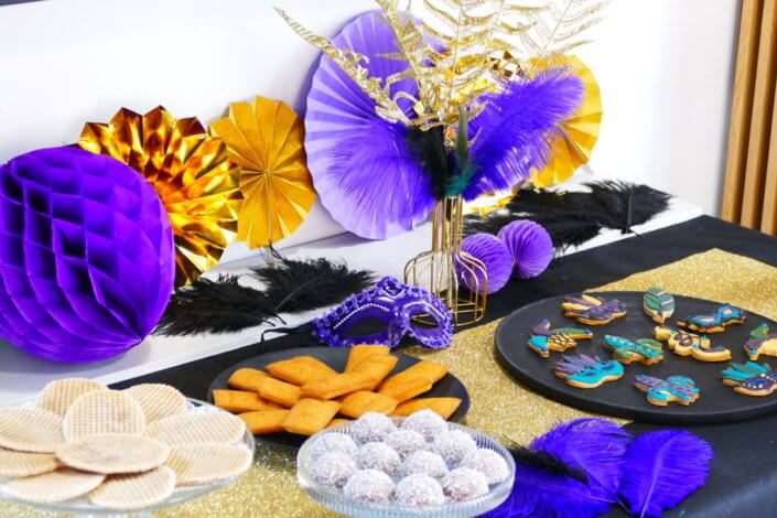 Afterwork Carnaval chez Bleu Libellule par Studio Candy avec décoration et set up sur mesure avec masques, plumes, vases, sablés décorés, brochettes de meringues, boissons
