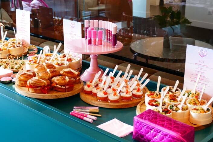 lancement événement Too Faced avec set up par Studio Candy avec pâtisseries sur mesure, sablés décorés mascara, madeleines roses pailletées, cakepops chocolats, panier de pêches, décoration et scénographie