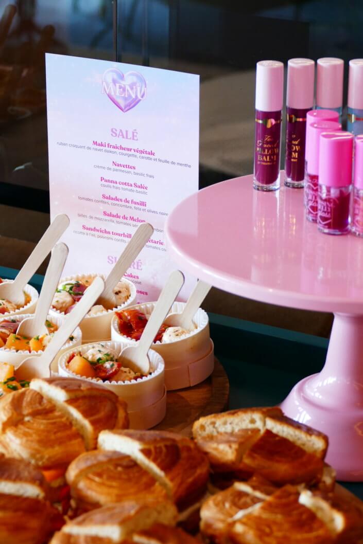 lancement événement Too Faced avec set up par Studio Candy avec pâtisseries sur mesure, sablés décorés mascara, madeleines roses pailletées, cakepops chocolats, panier de pêches, décoration et scénographie