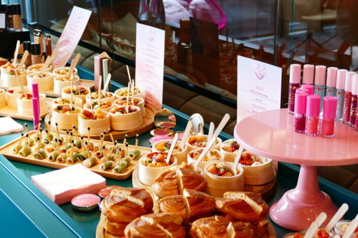 lancement événement Too Faced avec set up par Studio Candy avec pâtisseries sur mesure, sablés décorés mascara, madeleines roses pailletées, cakepops chocolats, panier de pêches, décoration et scénographie