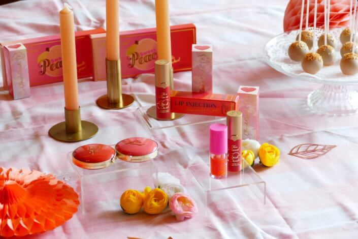 lancement événement Too Faced avec set up par Studio Candy avec pâtisseries sur mesure, sablés décorés mascara, madeleines roses pailletées, cakepops chocolats, panier de pêches, décoration et scénographie