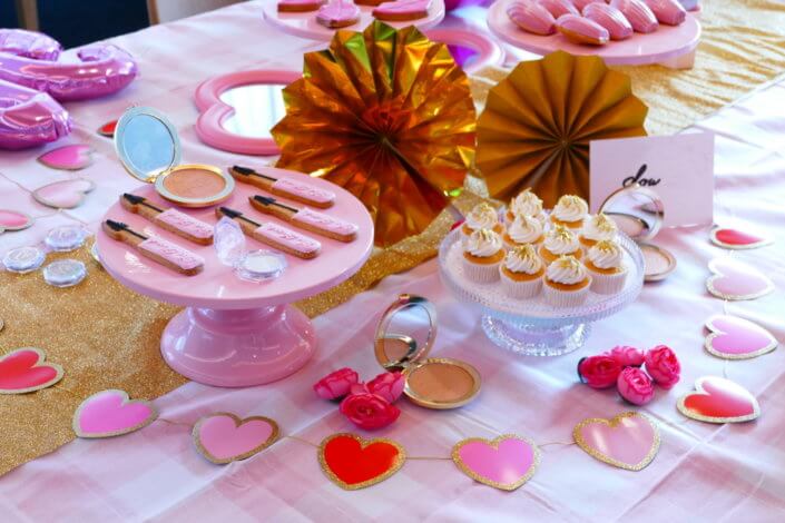 lancement événement Too Faced avec set up par Studio Candy avec pâtisseries sur mesure, sablés décorés mascara, madeleines roses pailletées, cakepops chocolats, panier de pêches, décoration et scénographie