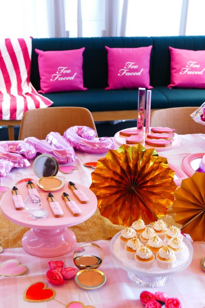 lancement événement Too Faced avec set up par Studio Candy avec pâtisseries sur mesure, sablés décorés mascara, madeleines roses pailletées, cakepops chocolats, panier de pêches, décoration et scénographie