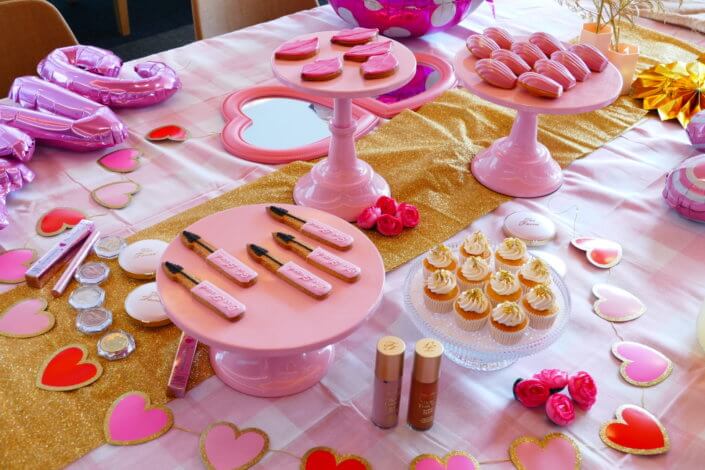 lancement événement Too Faced avec set up par Studio Candy avec pâtisseries sur mesure, sablés décorés mascara, madeleines roses pailletées, cakepops chocolats, panier de pêches, décoration et scénographie