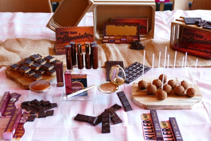 lancement événement Too Faced avec set up par Studio Candy avec pâtisseries sur mesure, sablés décorés mascara, madeleines roses pailletées, cakepops chocolats, panier de pêches, décoration et scénographie