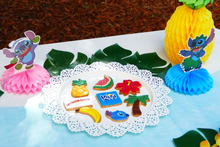 Goûter pour Kiri sur le thème de la nouvelle licence Lilo et Stitch qui sera présente sur les packagings. Table dressée sur mesure avec des cupcakes bleus, des sablés décorés Lilo et Stitch, décoration tropicale