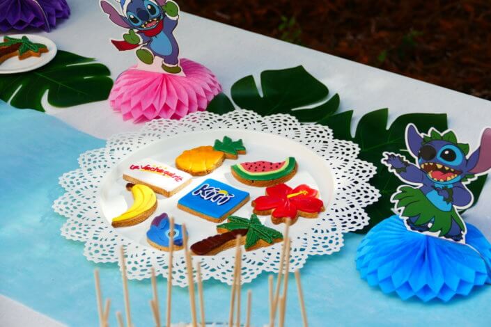 Goûter pour Kiri sur le thème de la nouvelle licence Lilo et Stitch qui sera présente sur les packagings. Table dressée sur mesure avec des cupcakes bleus, des sablés décorés Lilo et Stitch, décoration tropicale