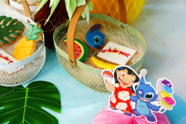 Goûter pour Kiri sur le thème de la nouvelle licence Lilo et Stitch qui sera présente sur les packagings. Table dressée sur mesure avec des cupcakes bleus, des sablés décorés Lilo et Stitch, décoration tropicale