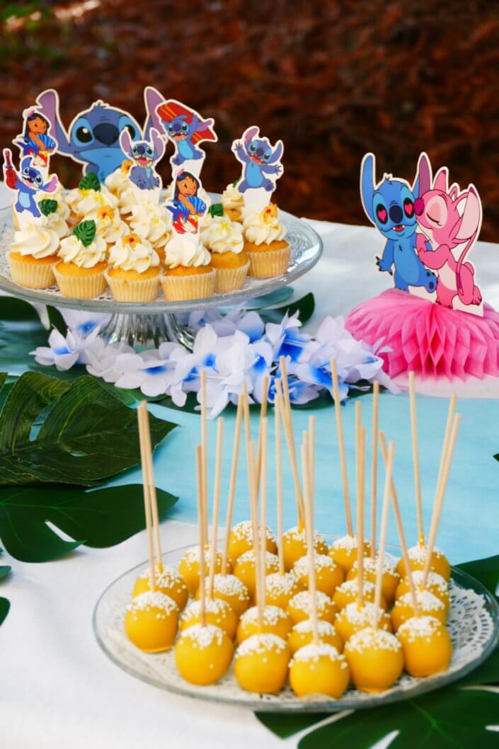 Goûter pour Kiri sur le thème de la nouvelle licence Lilo et Stitch qui sera présente sur les packagings. Table dressée sur mesure avec des cupcakes bleus, des sablés décorés Lilo et Stitch, décoration tropicale
