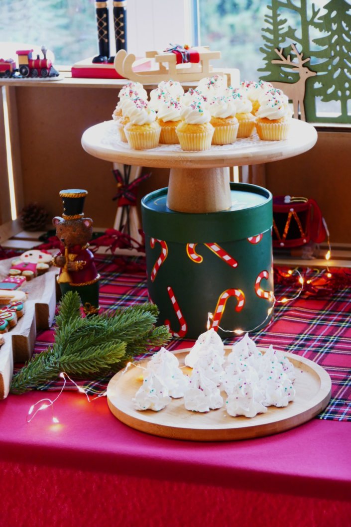Arbre de Noël chez Inicéa par Studio Candy avec un grand goûter de Noël traditionnel, sablés décorés, cakepops rouges, cupcakes, madeleines à coques rouges, et décoration en rouge, tartan écossais et sucres d'orge