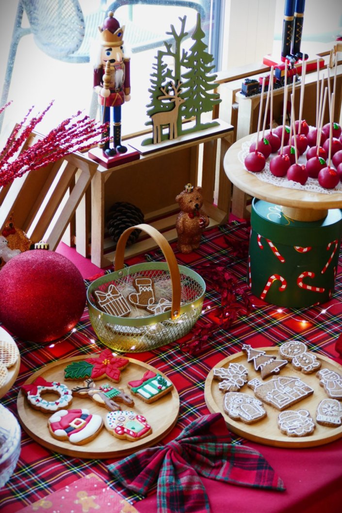 Arbre de Noël chez Inicéa par Studio Candy avec un grand goûter de Noël traditionnel, sablés décorés, cakepops rouges, cupcakes, madeleines à coques rouges, et décoration en rouge, tartan écossais et sucres d'orge