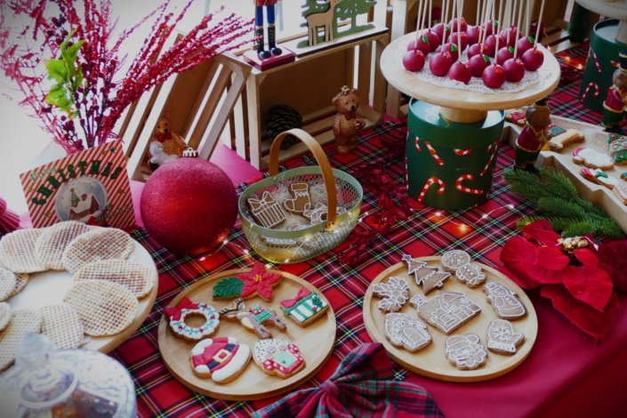 Arbre de Noël chez Inicéa par Studio Candy avec un grand goûter de Noël traditionnel, sablés décorés, cakepops rouges, cupcakes, madeleines à coques rouges, et décoration en rouge, tartan écossais et sucres d'orge