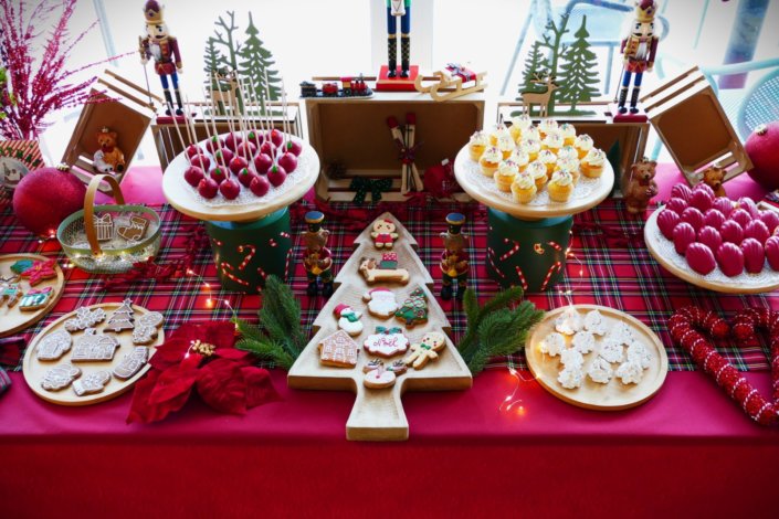 Arbre de Noël chez Inicéa par Studio Candy avec un grand goûter de Noël traditionnel, sablés décorés, cakepops rouges, cupcakes, madeleines à coques rouges, et décoration en rouge, tartan écossais et sucres d'orge