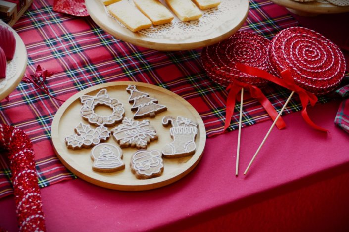 Arbre de Noël chez Inicéa par Studio Candy avec un grand goûter de Noël traditionnel, sablés décorés, cakepops rouges, cupcakes, madeleines à coques rouges, et décoration en rouge, tartan écossais et sucres d'orge