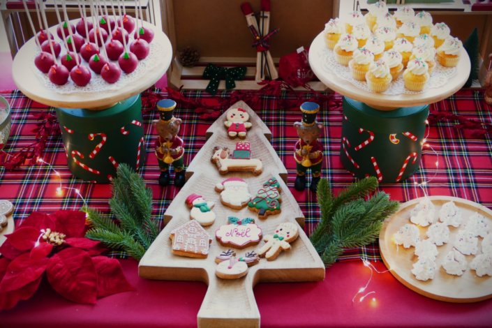 Arbre de Noël chez Inicéa par Studio Candy avec un grand goûter de Noël traditionnel, sablés décorés, cakepops rouges, cupcakes, madeleines à coques rouges, et décoration en rouge, tartan écossais et sucres d'orge