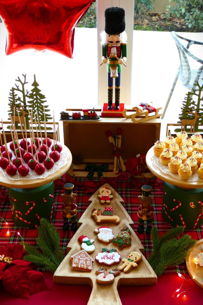 Arbre de Noël chez Inicéa par Studio Candy avec un grand goûter de Noël traditionnel, sablés décorés, cakepops rouges, cupcakes, madeleines à coques rouges, et décoration en rouge, tartan écossais et sucres d'orge