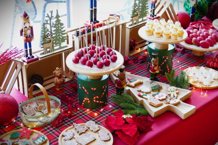 Arbre de Noël chez Inicéa par Studio Candy avec un grand goûter de Noël traditionnel, sablés décorés, cakepops rouges, cupcakes, madeleines à coques rouges, et décoration en rouge, tartan écossais et sucres d'orge