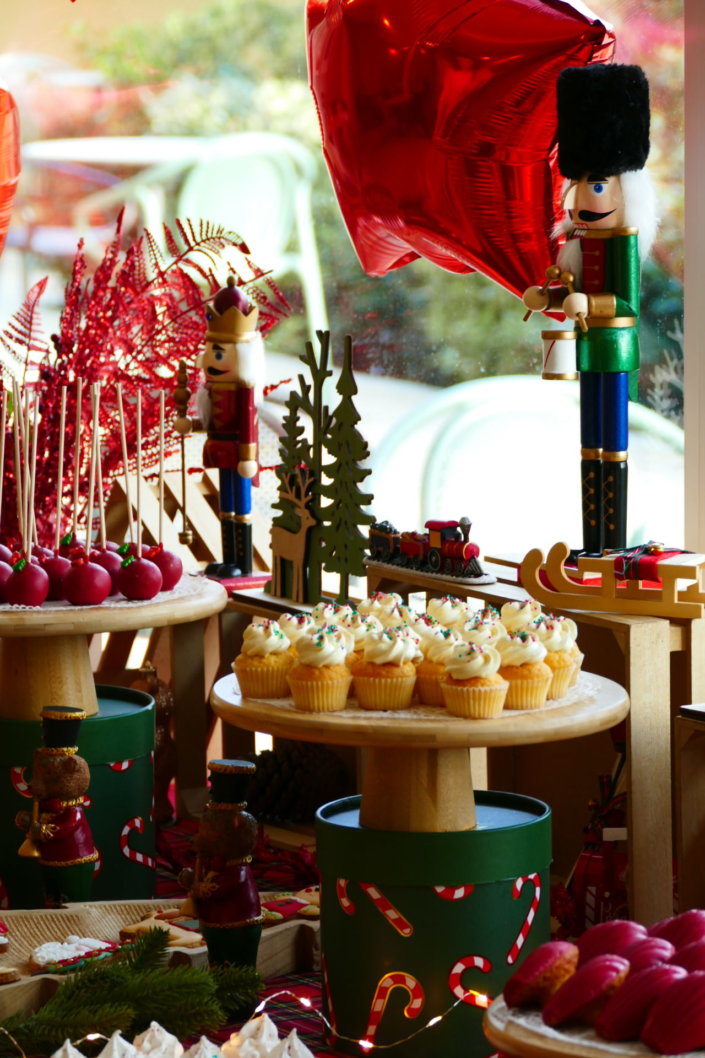 Arbre de Noël chez Inicéa par Studio Candy avec un grand goûter de Noël traditionnel, sablés décorés, cakepops rouges, cupcakes, madeleines à coques rouges, et décoration en rouge, tartan écossais et sucres d'orge
