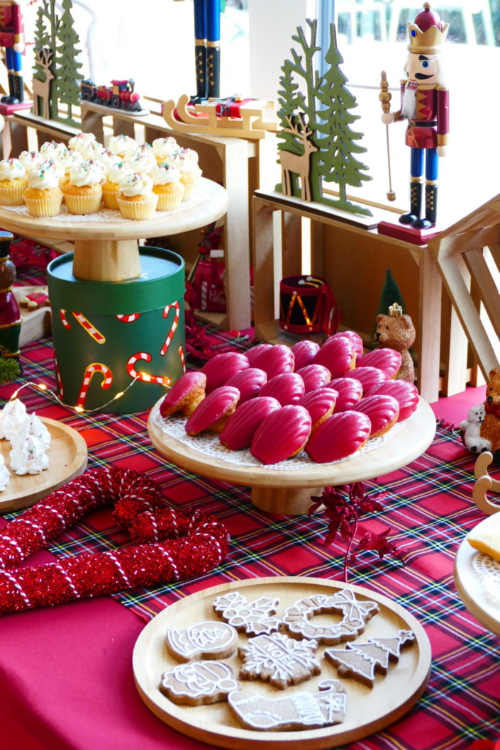 Arbre de Noël chez Inicéa par Studio Candy avec un grand goûter de Noël traditionnel, sablés décorés, cakepops rouges, cupcakes, madeleines à coques rouges, et décoration en rouge, tartan écossais et sucres d'orge