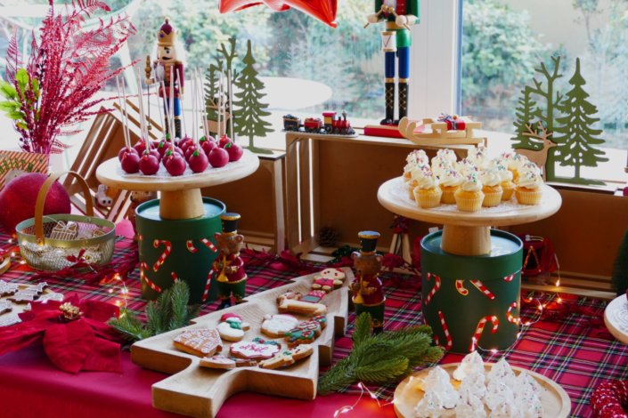 Arbre de Noël chez Inicéa par Studio Candy avec un grand goûter de Noël traditionnel, sablés décorés, cakepops rouges, cupcakes, madeleines à coques rouges, et décoration en rouge, tartan écossais et sucres d'orge