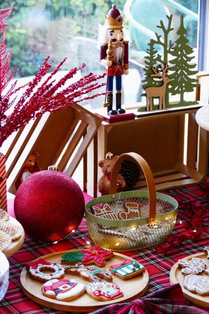Arbre de Noël chez Inicéa par Studio Candy avec un grand goûter de Noël traditionnel, sablés décorés, cakepops rouges, cupcakes, madeleines à coques rouges, et décoration en rouge, tartan écossais et sucres d'orge