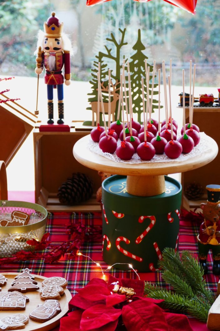Arbre de Noël chez Inicéa par Studio Candy avec un grand goûter de Noël traditionnel, sablés décorés, cakepops rouges, cupcakes, madeleines à coques rouges, et décoration en rouge, tartan écossais et sucres d'orge