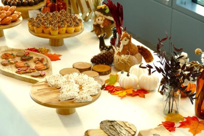 Goûter d'automne pour Axa par Studio Candy avec une scénographie et décoration automnale, des sablés décorés aux épices, des madeleines à coques orangées, des cupcakes pralinés