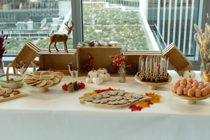 Goûter d'automne pour Axa par Studio Candy avec une scénographie et décoration automnale, des sablés décorés aux épices, des madeleines à coques orangées, des cupcakes pralinés