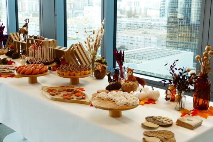 Goûter d'automne pour Axa par Studio Candy avec une scénographie et décoration automnale, des sablés décorés aux épices, des madeleines à coques orangées, des cupcakes pralinés