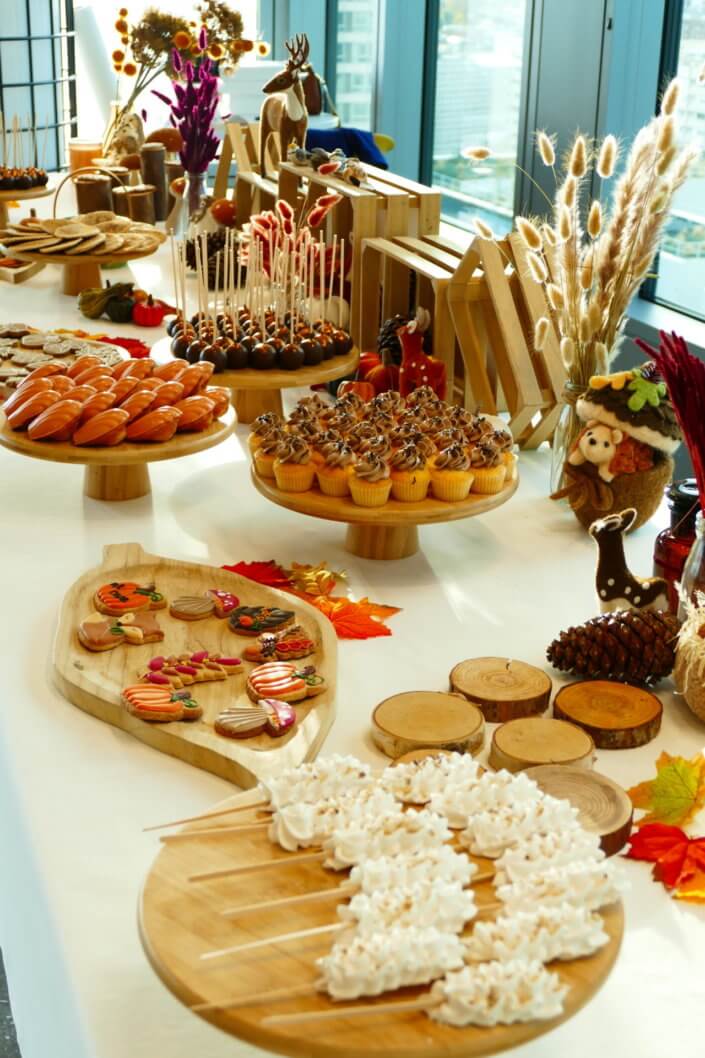 Goûter d'automne pour Axa par Studio Candy avec une scénographie et décoration automnale, des sablés décorés aux épices, des madeleines à coques orangées, des cupcakes pralinés