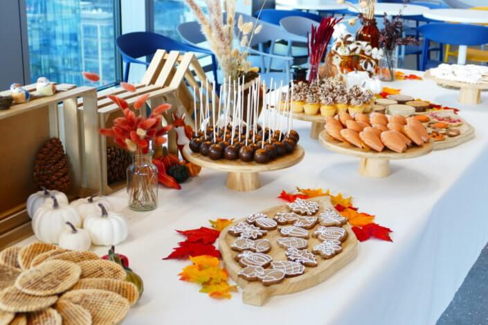 Goûter d'automne pour Axa par Studio Candy avec une scénographie et décoration automnale, des sablés décorés aux épices, des madeleines à coques orangées, des cupcakes pralinés