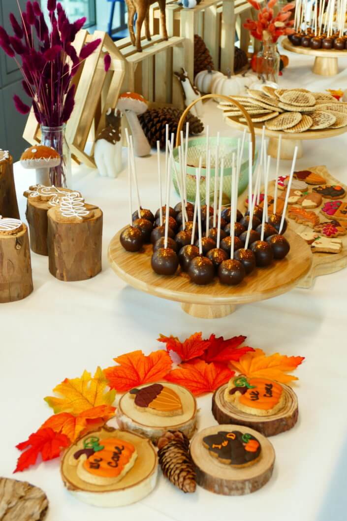 Goûter d'automne pour Axa par Studio Candy avec une scénographie et décoration automnale, des sablés décorés aux épices, des madeleines à coques orangées, des cupcakes pralinés