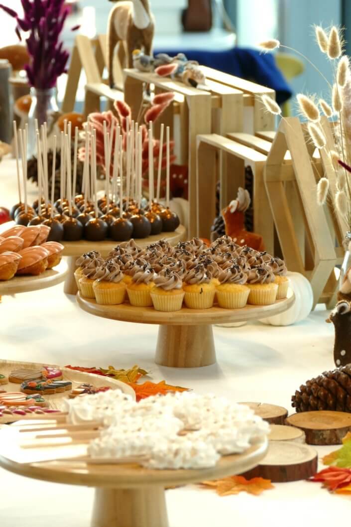 Goûter d'automne pour Axa par Studio Candy avec une scénographie et décoration automnale, des sablés décorés aux épices, des madeleines à coques orangées, des cupcakes pralinés