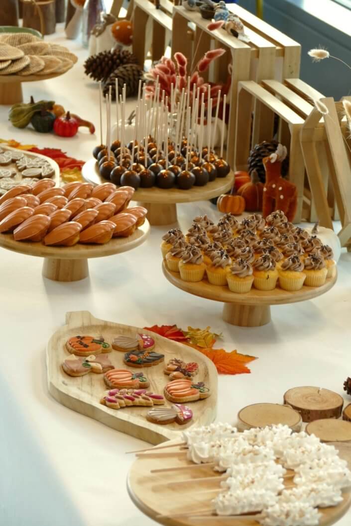Goûter d'automne pour Axa par Studio Candy avec une scénographie et décoration automnale, des sablés décorés aux épices, des madeleines à coques orangées, des cupcakes pralinés