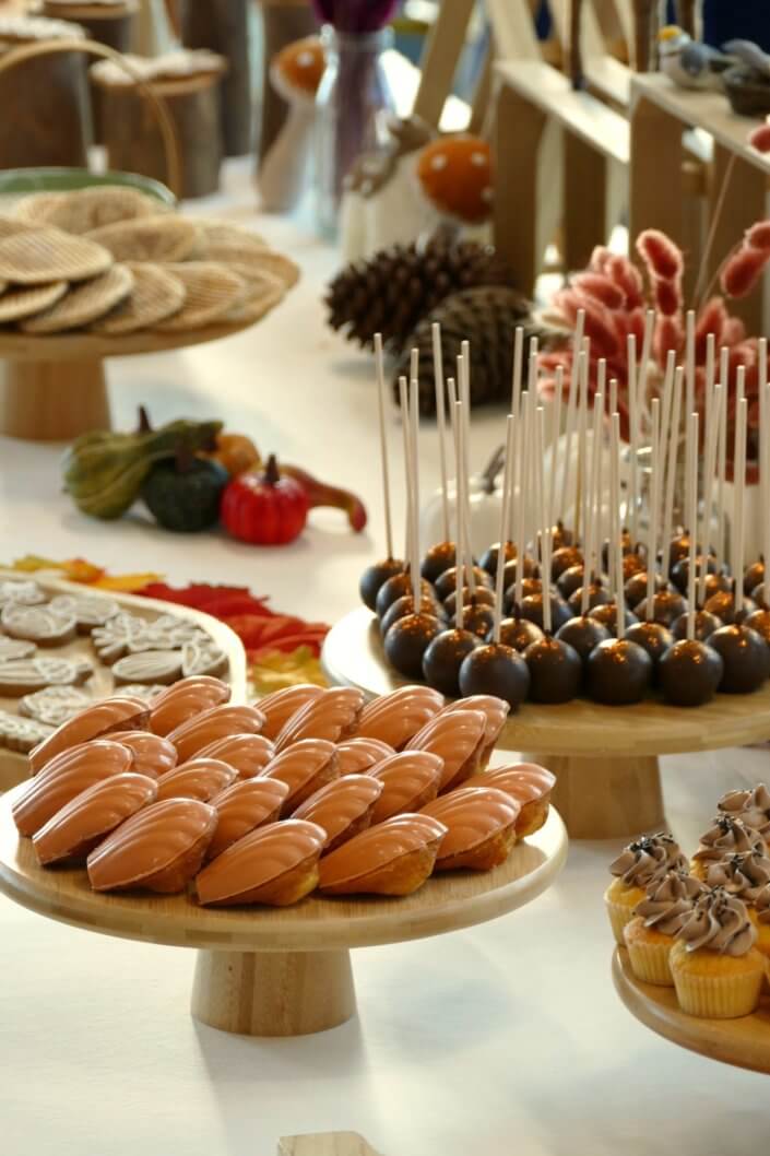 Goûter d'automne pour Axa par Studio Candy avec une scénographie et décoration automnale, des sablés décorés aux épices, des madeleines à coques orangées, des cupcakes pralinés