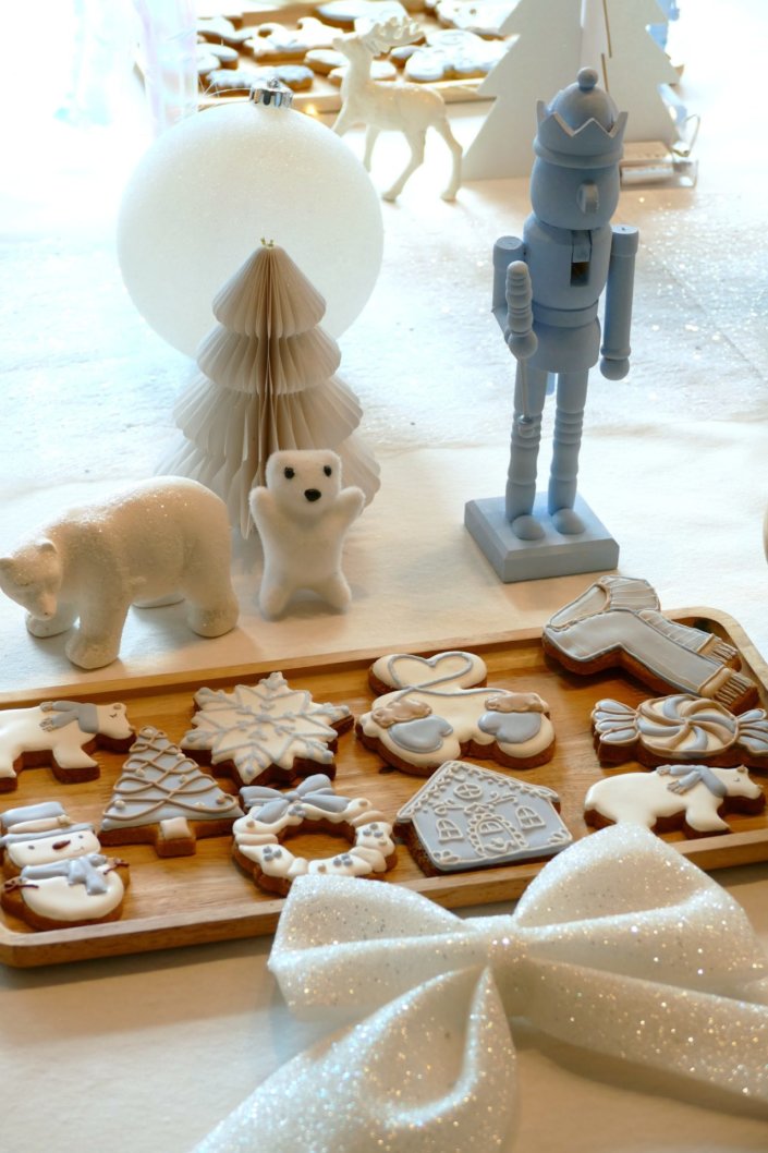 Arbre de Noël thème polaire en blanc, bleu glacier et argent : madeleines à coques bleues, sablés décorés de Noël, cakepops blancs à paillettes, cupcakes et décoration ours polaire, pingouin et casses noisettes bleu pastel peints à la main