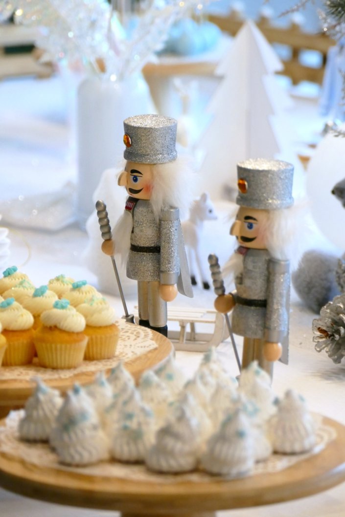 Arbre de Noël thème polaire en blanc, bleu glacier et argent : madeleines à coques bleues, sablés décorés de Noël, cakepops blancs à paillettes, cupcakes et décoration ours polaire, pingouin et casses noisettes bleu pastel peints à la main