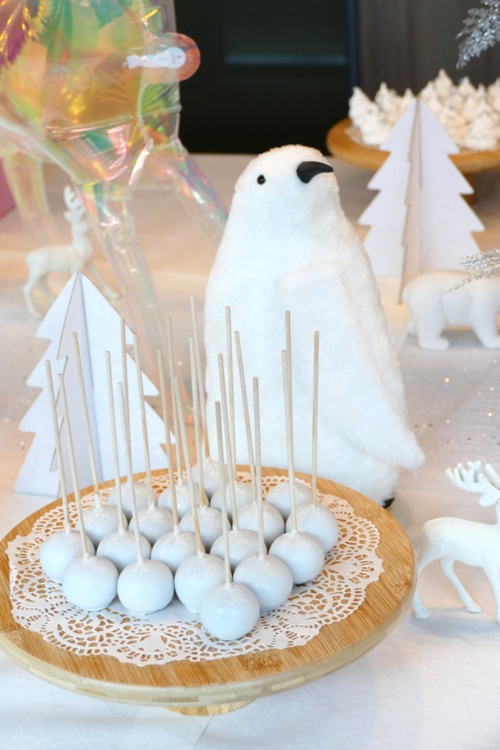 Arbre de Noël thème polaire en blanc, bleu glacier et argent : madeleines à coques bleues, sablés décorés de Noël, cakepops blancs à paillettes, cupcakes et décoration ours polaire, pingouin et casses noisettes bleu pastel peints à la main