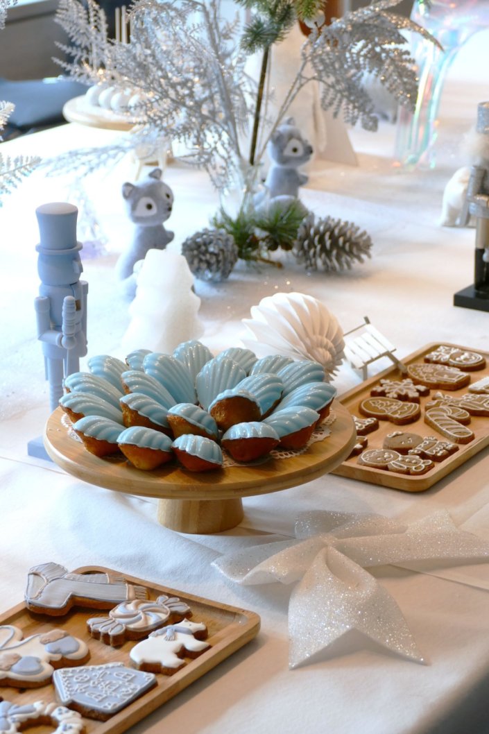 Arbre de Noël thème polaire en blanc, bleu glacier et argent : madeleines à coques bleues, sablés décorés de Noël, cakepops blancs à paillettes, cupcakes et décoration ours polaire, pingouin et casses noisettes bleu pastel peints à la main