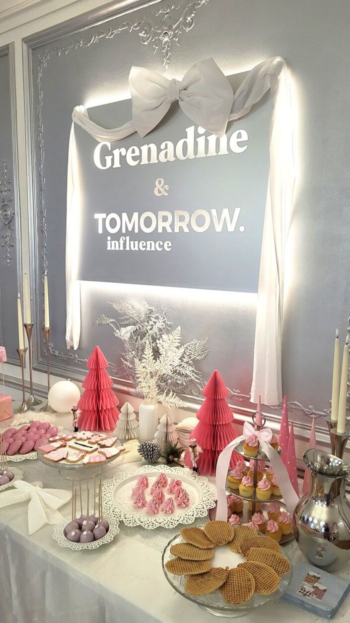 Goûter de Noël en rose et blanc pour l'agence Grenadine Rp par Studio Candy avec des pâtisseries sur mesure, un set up et une décoration rose pastel, blanc et argent