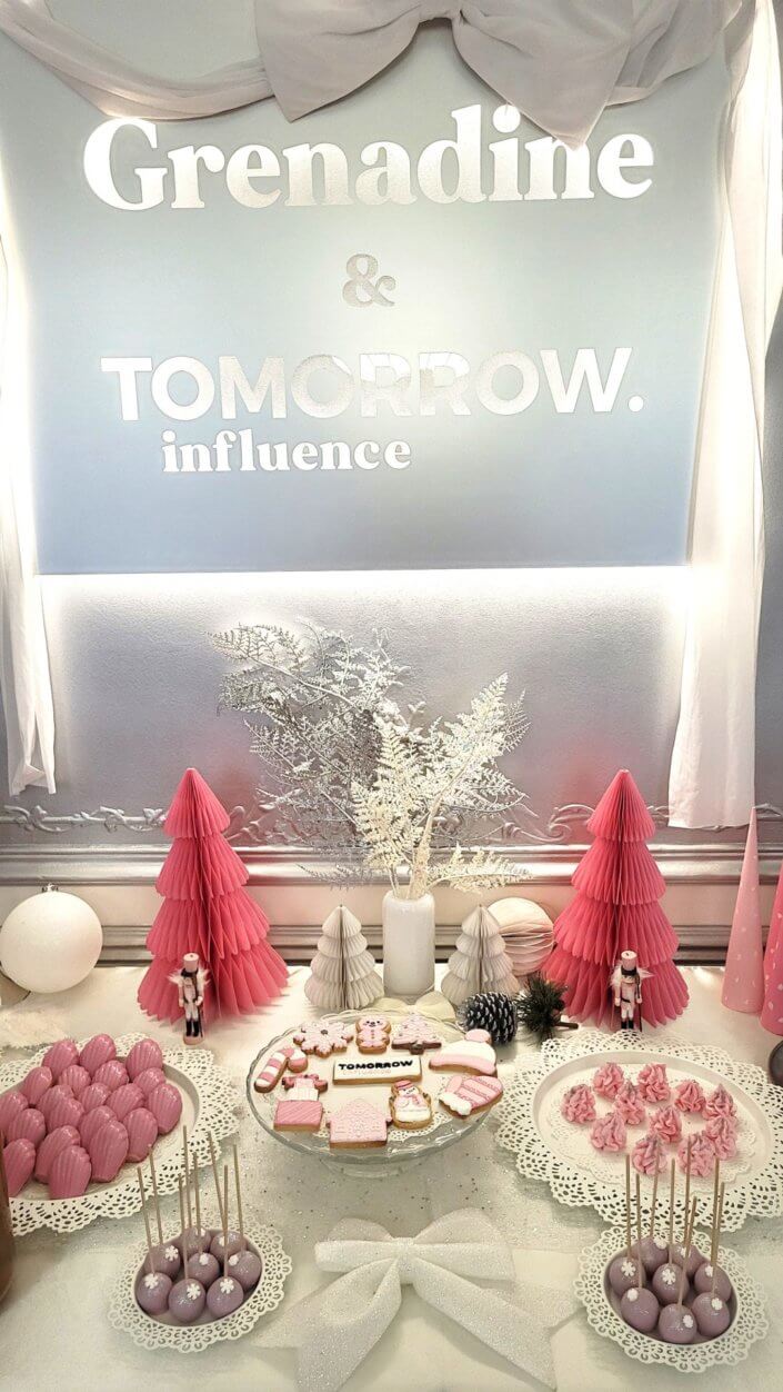 Goûter de Noël en rose et blanc pour l'agence Grenadine Rp par Studio Candy avec des pâtisseries sur mesure, un set up et une décoration rose pastel, blanc et argent